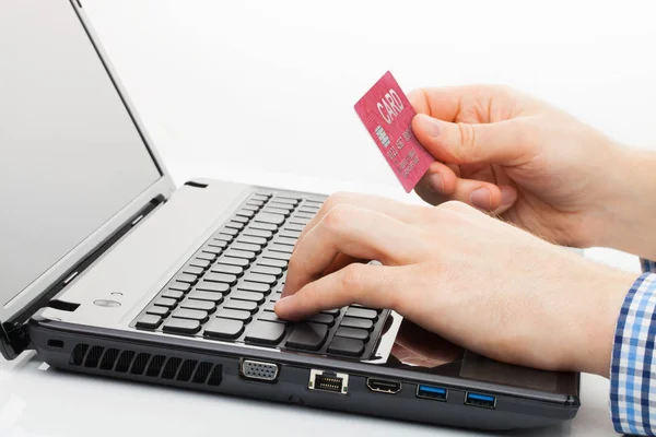 Man holding a credit card next to computer keyboard and trying to do online shopping — Stock Photo, Image