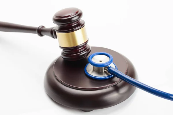 Close up shot of a wooden judge gavel and a stethoscope — Stock Photo, Image