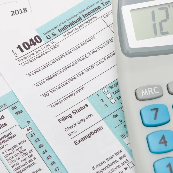 Formularz podatkowy USA 1040 i Kalkulator nad nim - z bliska strzał studio — Zdjęcie stockowe