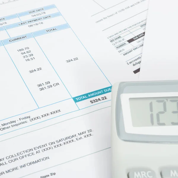 Unpaid utility bill and calculator next to it - close up studio shot — Stock Photo, Image