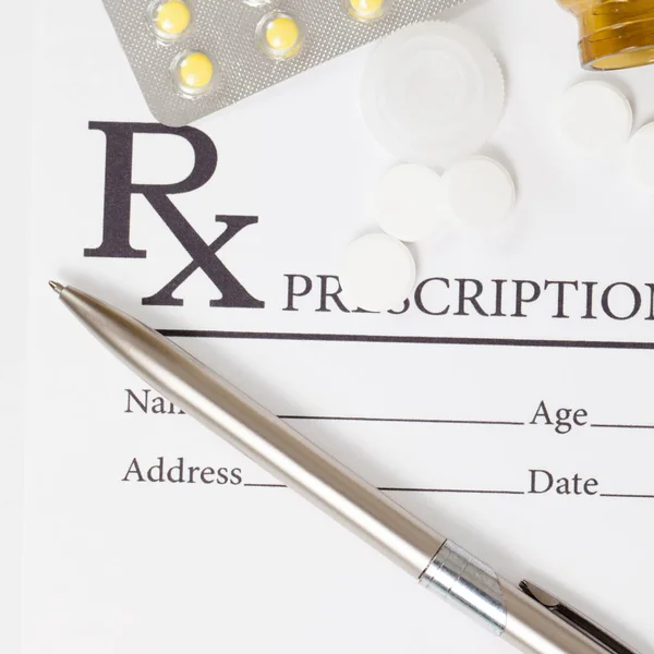 Different pills and silver color pen over medical prescription form - close up studio shot — Stock Photo, Image