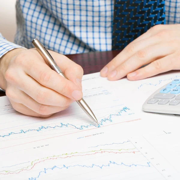 Geschäftswelt und ihre Symbole - Geschäftsmann beschäftigt mit Berechnungen über einige finanzielle Daten — Stockfoto