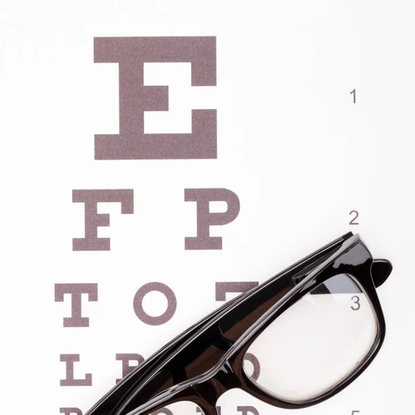 Tabla de prueba de la vista con gafas sobre él - cerca estudio tiro — Foto de Stock
