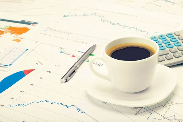 커피 컵 그리고 세계 지도 및 일부 금융 차트 계산기. 필터링 된 이미지: 크로스 처리 빈티지 효과. — 스톡 사진