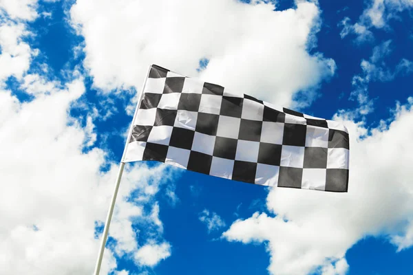 Checkered flag waving in the wind with clouds on background - outdoors shoot. Filtered image: cross processed vintage effect. — Stock Photo, Image