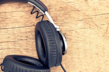 Ahşap masa - retro müzik konsepti düzgün vintage kulaklıklar. Filtre uygulanan görüntü: çapraz işlenen vintage etkisi.