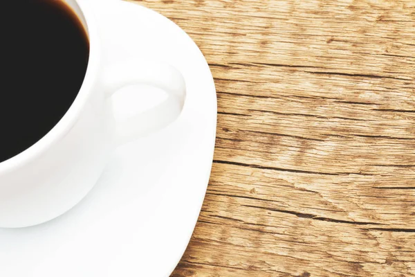 Cup of black coffee on old wooden table - shot from top. Filtered image: cross processed vintage effect. — Stock Photo, Image