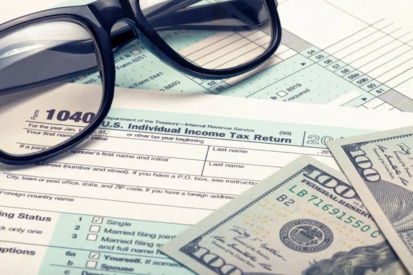 US 1040 Tax Form with glasses and dollars - studio shot. Filtered image: cross processed vintage effect. — Stock Photo, Image