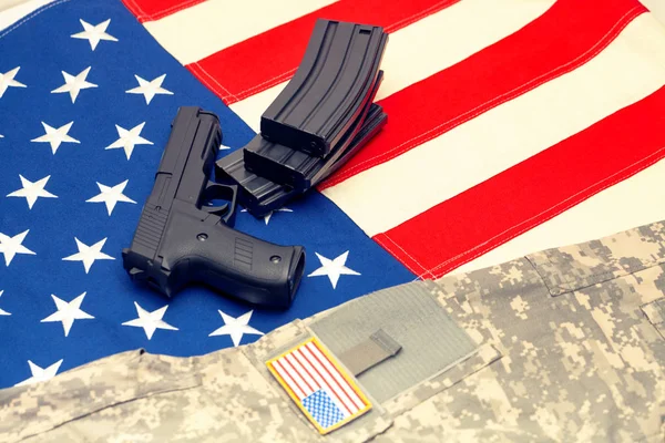 Handgun and US army uniform over USA flag. Filtered image: cross processed vintage effect. — Stock Photo, Image