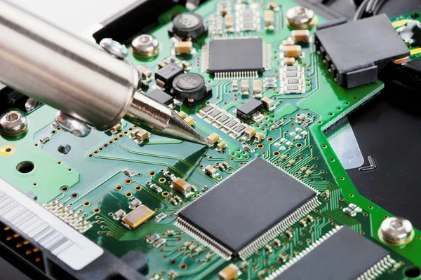 Soldeerbout en microcircuit - close-up studio opname. Gefilterde afbeelding: Kruis verwerkt vintage effect. — Stockfoto