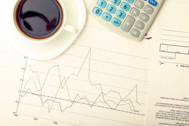 Kahve fincanı finansal belgeler üzerinde - üstten görüntülemek. Filtre uygulanan görüntü: çapraz işlenen vintage etkisi.