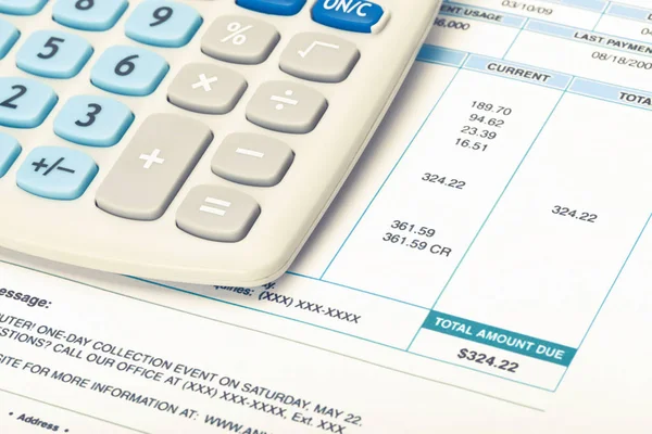 Calculator with utility bill under it. Filtered image: cross processed vintage effect. — Stock Photo, Image