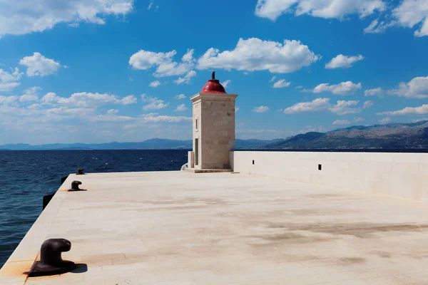 Faro en el puerto de una ciudad pequeña durante el día - Croacia, isla de Brac — Foto de Stock