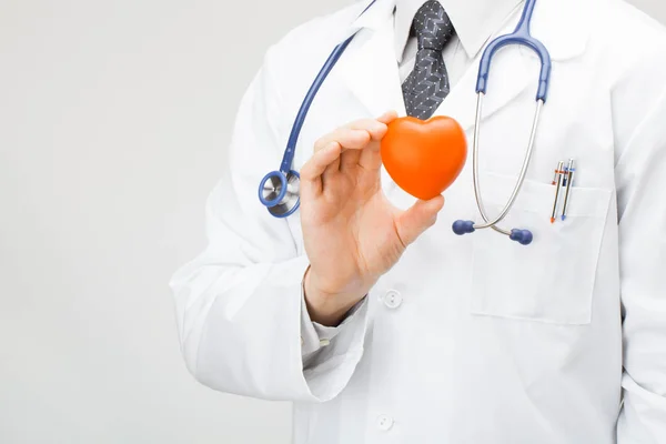 Läkaren håller leksak-hjärtat i handen — Stockfoto