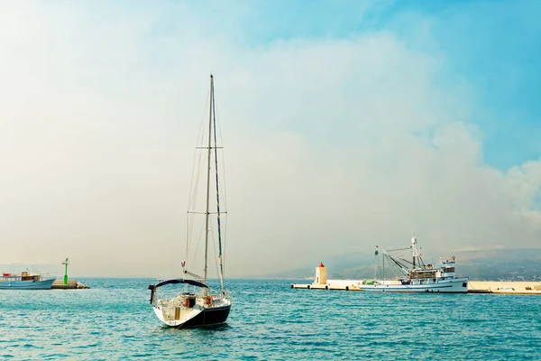 Moored yacht and a fishing trawler in the harbor of a small town called Postira - Croatia, island Brac — Stock Photo, Image