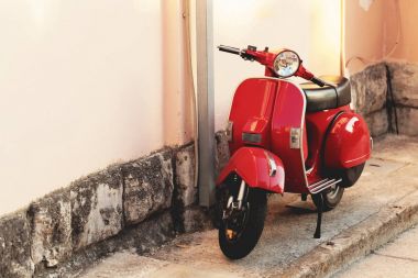 Kırmızı vintage scooter açık havada ateş bir bina duvara yakın - park