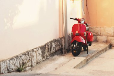 Kırmızı vintage scooter bir bina duvara yakın park