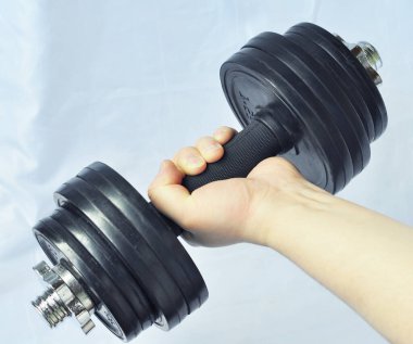 Erkek el ağır bir dambıl tutar.