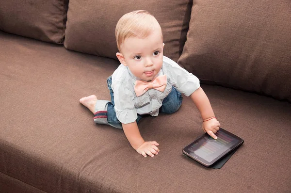 Kleiner Junge Sitzt Auf Sofa Und Hält Tablet — Stockfoto
