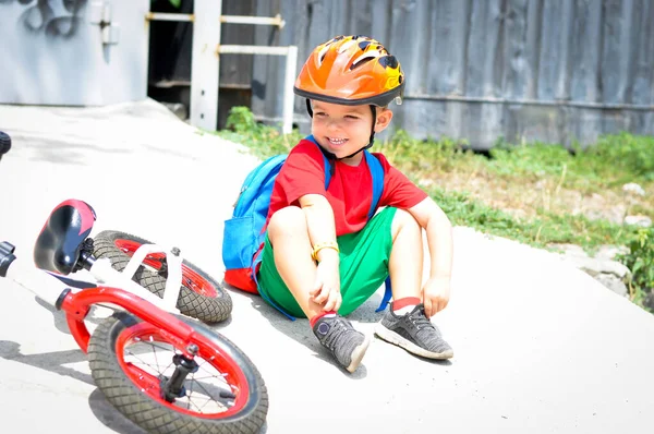 スポーツ子供男の子で保護ヘルメット近くに彼の赤い白いバランスの自転車 — ストック写真