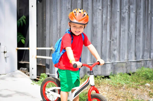 スポーツ子供男の子で保護ヘルメット近くに彼の赤い白いバランスの自転車 — ストック写真