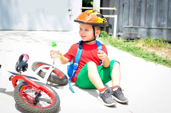 スポーツ子供男の子で保護ヘルメット近くに彼の赤い白いバランスの自転車 — ストック写真