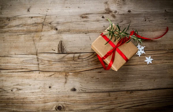 Weihnachtsgeschenk in Bastelpapier auf Holzgrund gewickelt — Stockfoto