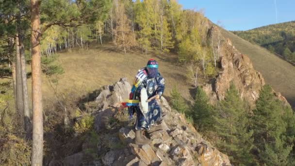 Foto aérea de un misterioso ritual mágico de un chamán de montaña de pie sobre una roca . — Vídeos de Stock