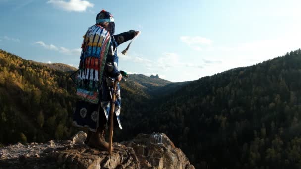 Varázslatos sámáni rituálé haranggal a hegy tetején. — Stock videók