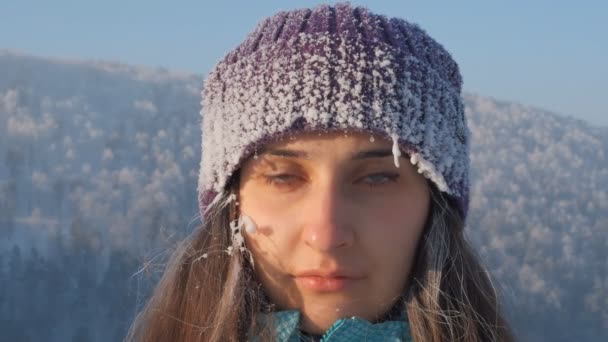 Retrato em câmera lenta de uma jovem atraente mulher congelada sorrindo na paisagem de inverno . — Vídeo de Stock