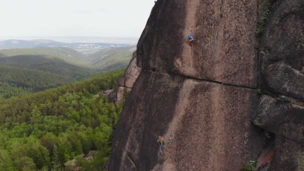 Två klättrare gör uppstigningen på den vertikala väggen. — Stockvideo