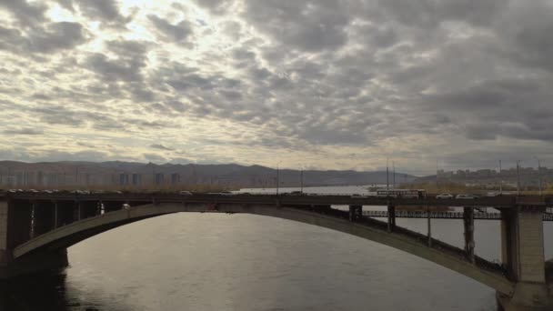 Circulation urbaine sur le pont sur la rivière . — Video