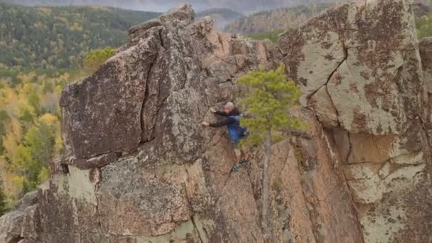 Bergbeklimmer klimt naar de top. Een drone schot.. — Stockvideo