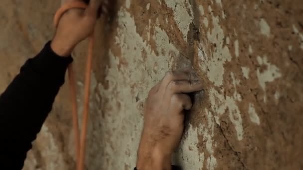 Close-up van de handen van een klimmer die de muur beklimt en zich verzekert. — Stockvideo