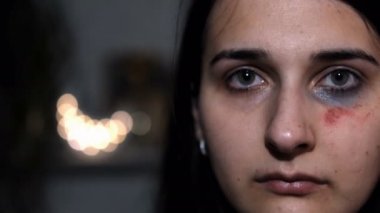 Aile içi şiddetin kurbanı genç bir kadının ağır çekim portresi. Yüzünde sıyrıklar var..