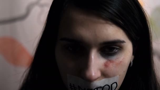 A young female victim of violence raises her head and shows the word "metoo" on her face. — 비디오