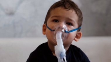 Tıbbi maske takan üzgün küçük bir çocuğun yavaş çekim portresi..