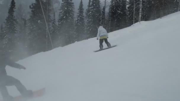 Lassú mozgás a barátok snowboardosok lovagolni a hegyről. — Stock videók