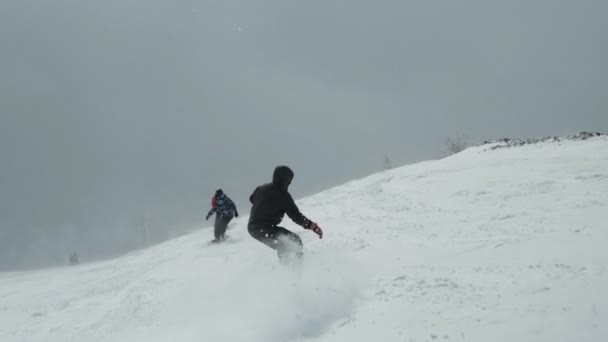 Een groep snowboarders en skiërs op de besneeuwde pisten van het skigebied. — Stockvideo