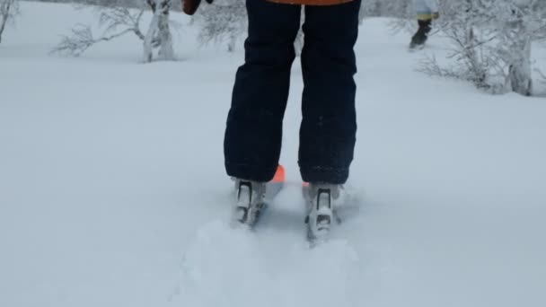 Movimento lento de uns esquiadores patinagem de pés na neve . — Vídeo de Stock