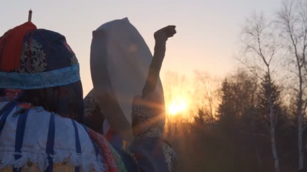 Langzame beweging van de sjamaan verslaat de tamboerijn bij zonsondergang. — Stockvideo