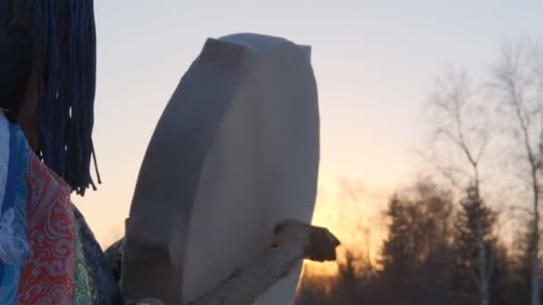 Primer plano de una pandereta en manos de un chamán que juega al atardecer . — Vídeo de stock