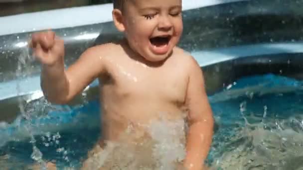 Gros plan d'un enfant qui s'amuse à nager dans une piscine extérieure . — Video