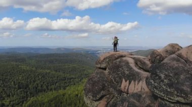 Genç bir babanın, sırt çantasında oturan küçük çocuğuna dağları gösteren hava manzarası. Aile turizmi.