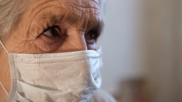 Close-up do rosto de uma mulher idosa em uma máscara protetora médica . — Vídeo de Stock