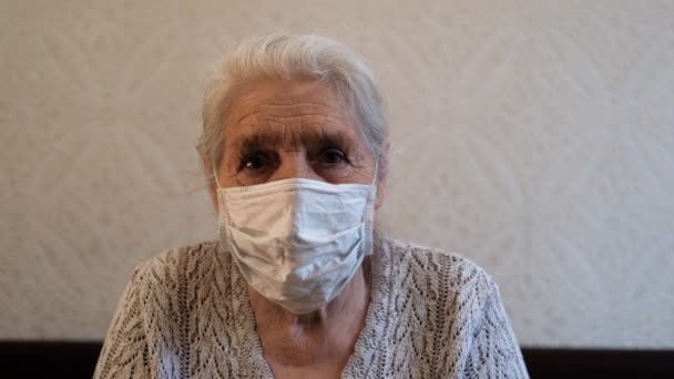 Retrato de cerca de una anciana feliz de pelo gris con una máscara médica protectora . — Vídeos de Stock