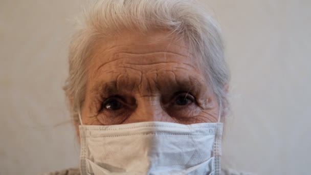 Gros plan sur les yeux d'une femme âgée portant un masque protecteur . — Video