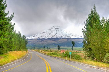 View of the Cotopaxi volcano, from the entrance to the Cotopaxi National Park, on an overcast day. clipart