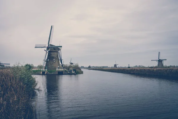 Scenic Shot Windmills River Bank Netherlands Cloudy Day ストックフォト