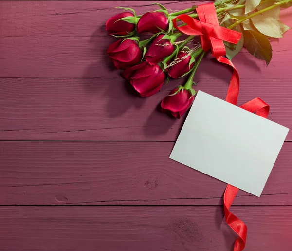 San Valentino rose e carta bianca su uno sfondo di legno colorato — Foto Stock